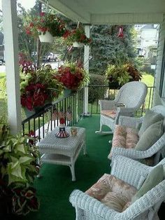 the porch is decorated with white wicker furniture