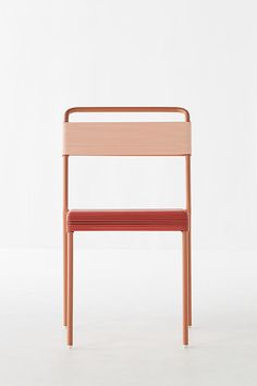 a wooden chair sitting on top of a white floor next to a red seat cushion