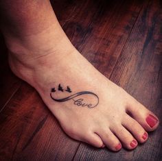 a woman's foot with a tattoo on it that says love and birds flying in the sky