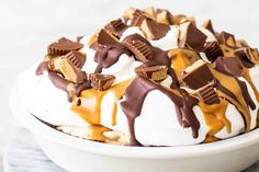 a white bowl filled with chocolate and marshmallows on top of a marble counter