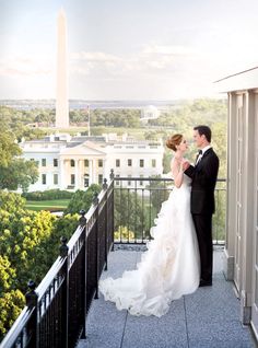 a bride and groom are standing on the balcony overlooking the washington monument