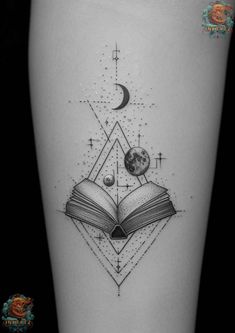 an open book with planets and stars on the cover - up tattoo is shown in black ink