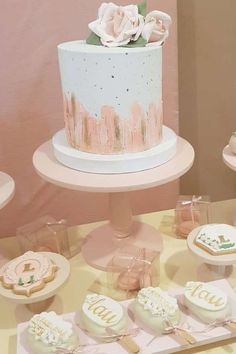 a table topped with cakes and cupcakes covered in frosting