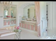 a large bathroom with pink walls and white floors, chandelier over the bathtub