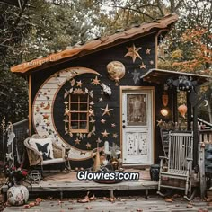 a small house with stars and moon decorations on the front door is shown in an outdoor setting