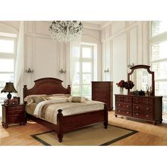 a bedroom scene with focus on the bed, dresser and two nightstands in front of windows