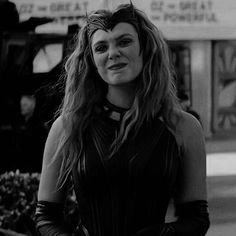 a woman with long hair standing on the street