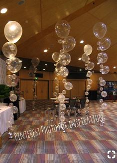 an indoor event with clear balloons hanging from the ceiling