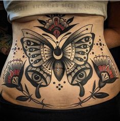 a woman's stomach with an intricate butterfly tattoo on her belly and the lower part of her abdomen