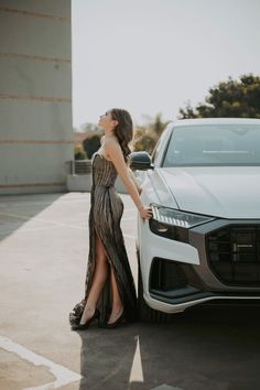 a woman standing next to a white car