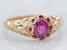 This Victorian solitaire ring would make a lovely alternative engagement ring! The mounting is crafted from rosy 18-karat gold, with ornately patterned shoulders and a buttercup style Belcher setting, classic to the era. We've set this antique ring with a pretty pink sapphire, a deep-colored stone with flashes of raspberry and ruby!Metal: 18K Yellow Gold, 18K Rose Gold ProngsGem: Pink Sapphire Gem Measurements: 5.4 mm, RoundRing Size: 7Marks: "18K (G)" Stamped on the inside bandd Antique Engagement Rings Victorian, Ruby Engagement Rings, Sapphire Gem, Pink Sapphire Ring Engagement, Sapphire Solitaire Ring, Alternative Engagement Ring, Sapphire Solitaire, Pink Sapphire Ring, Antique Ring