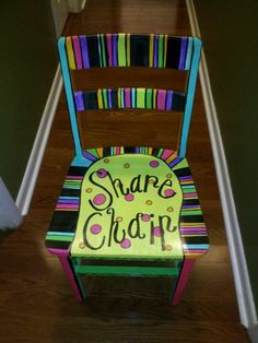 a colorful wooden chair sitting on top of a hard wood floor