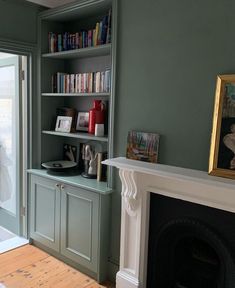 a living room filled with furniture and a fire place next to a fireplace covered in books