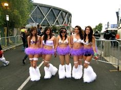 four women in purple and white costumes are posing for the camera