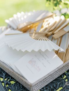 a table topped with lots of paper and fan shaped place settings on top of each other