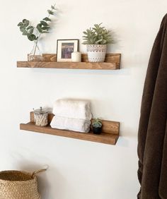 two wooden shelves with towels and plants on them