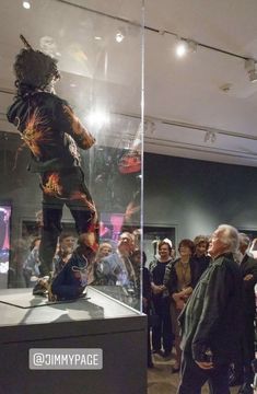 people are looking at an exhibit in a glass case with a bear on it's back