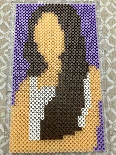 an image of a woman made out of perler beads on a piece of fabric