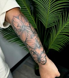 a person with a tattoo on their arm holding a plant in front of them,