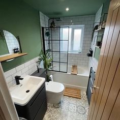 a bathroom with green walls and white fixtures