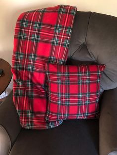 a red and black plaid pillow sitting on top of a couch