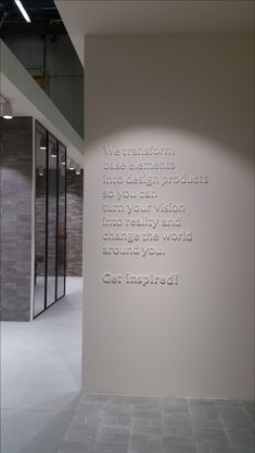 a white wall with words on it in an empty room next to some glass doors