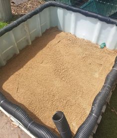 a large amount of sand is in the back of a truck with a hose attached to it