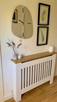 a white radiator sitting next to a wall with pictures and plants on it