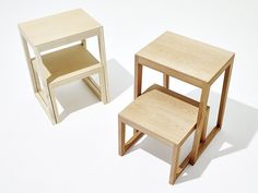 two small wooden tables sitting next to each other on a white surface in front of a light colored background