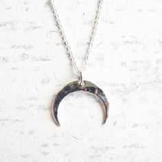 "Small Sterling Silver Hammered Crescent Moon Pendant on 16\" Sterling Silver Chain. Legends relate that people once believed the moon was made of silver. So, they would ask the moon for help and jingle the change in their pockets as they gazed at it's glory. Perhaps when you wear this necklace, you can touch it and look to the moon for energy and inspiration.  Sterling silver 16mm charm on sterling silver chain." Spiritual Silver Charm Necklaces With Moon Phase, Spiritual Silver Charm Necklace With Moon Phase, Half Moon Metal Necklace For Gift, Half Moon Metal Necklace For Gifts, Silver Half Moon Necklace With Sun And Moon Design, Spiritual Crescent Moon Phase Charm Necklace, Silver Moon Necklace With Engraving, Sterling Silver Moon Phase Charm Necklace, Nickel Free Silver Moon Necklace