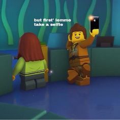 a lego character holding up a cell phone to take a selfie with another person