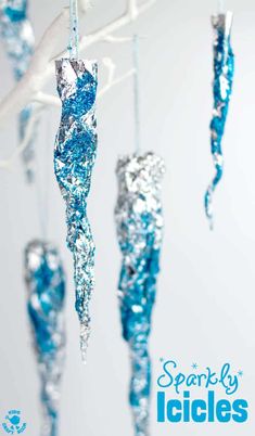 blue and silver ornaments hanging from a branch with the words spooky lights on it