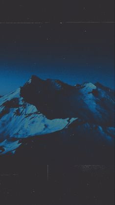 the snow covered mountains are lit up at night