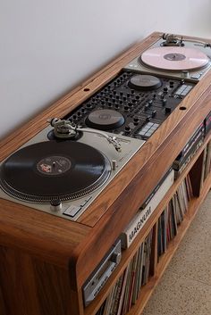 a record player sitting on top of a wooden shelf next to a wall mounted cd player