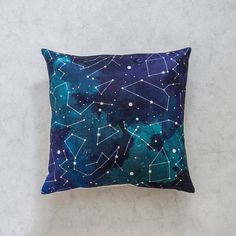 a blue and white pillow with stars in the night sky on top of a concrete wall