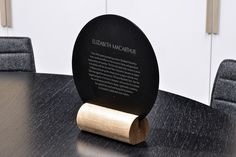 a black plaque sitting on top of a wooden table