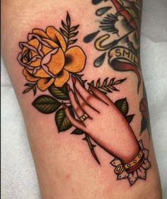 a woman's hand with yellow roses on her arm and the word love is written in