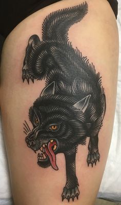 a black and white tattoo with an animal on it's thigh, showing its teeth