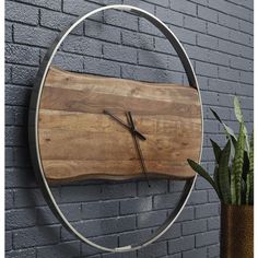 a clock mounted to the side of a brick wall next to a potted plant