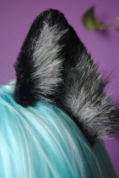 the back of a person's head with blue hair and black fur on it