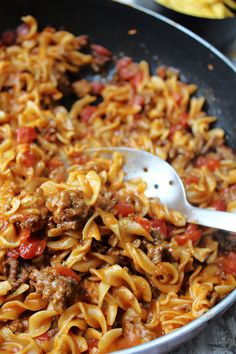 a skillet filled with pasta and meat