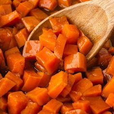 a wooden spoon is full of chopped carrots