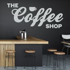 the coffee shop is decorated with white lettering and wooden stools in front of it