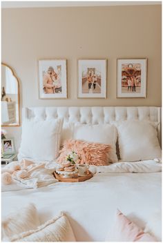 a white bed topped with pillows and blankets next to pictures on the wall above it