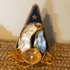 an ornament shaped like a sailboat on top of a woven table cloth