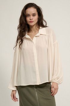 Solid chiffon shirt. Collared neckline. Button front closure. Long bubble sleeves with elastic cuffs. Drop shoulder. Gathered yoke Curved shirttail hem. Semi sheer. Oversized fit. 100% Polyester. Imported. Designed in LA. Model wears size S. Flowy Long Sleeve Chiffon Blouse, Long Sleeve Chiffon Blouse For Daywear, Flowy Chiffon Trendy Blouse, Trendy Flowy Chiffon Blouse, Flowy Chiffon Casual Blouse, Flowy Casual Chiffon Blouse, Casual Flowy Chiffon Blouse, Casual Chiffon Blouse For Fall, Casual Lantern Sleeve Blouse With Button Closure