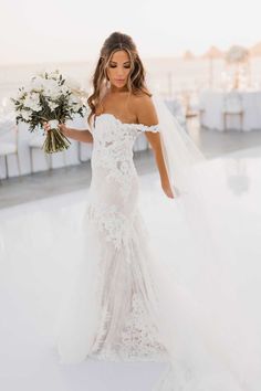 a woman in a wedding dress holding a bouquet