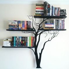 there is a tree that has books on it and some shelves in the shape of a bookcase