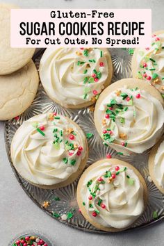 sugar cookies with white frosting and sprinkles are on a platter