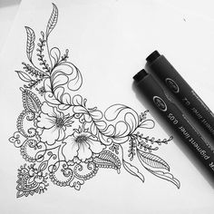 an ink pen and some flowers on top of a piece of paper